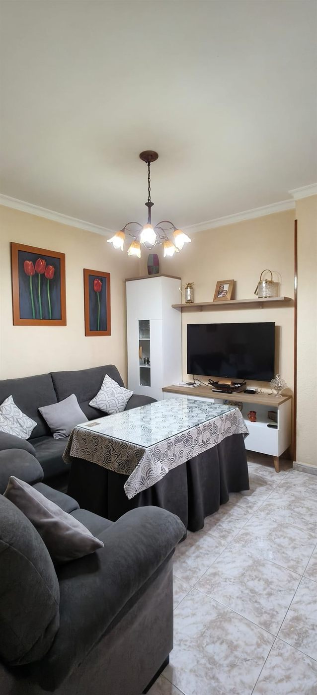 Sala de estar con sofá rinconera del ático dúplex en Fregenal de la Sierra